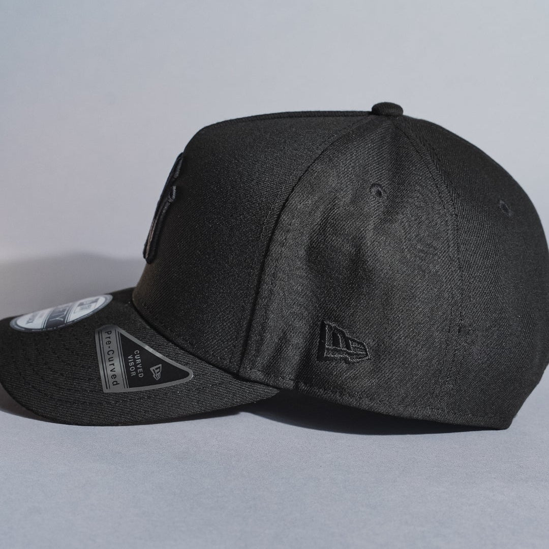 NEW ERA 9FIFTY A-FRAME BLACKED OUT NEW YORK YANKEES SNAPBACK W/ 1999 WORLD SERIES SIDE PATCH