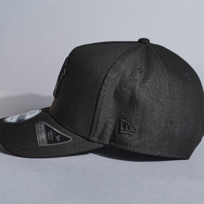 NEW ERA 9FIFTY A-FRAME BLACKED OUT NEW YORK YANKEES SNAPBACK W/ 1999 WORLD SERIES SIDE PATCH